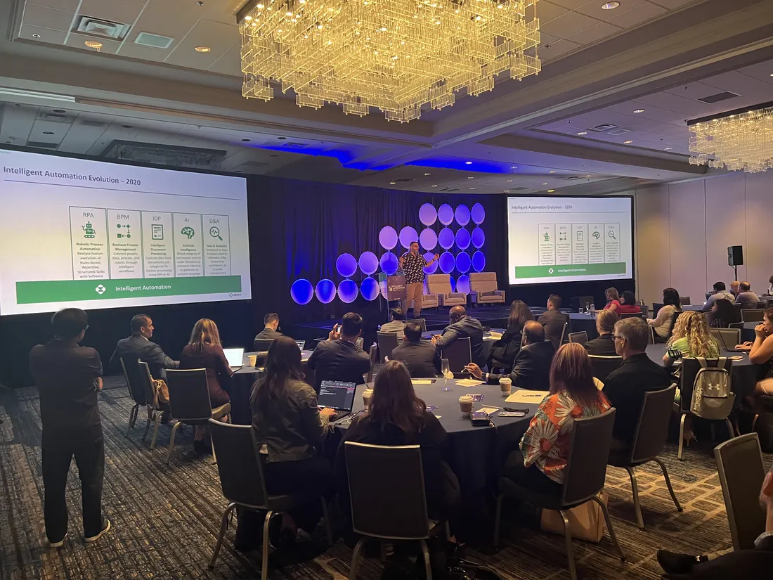 Conference ballroom in Chicago with screens and a lit stage backdrop